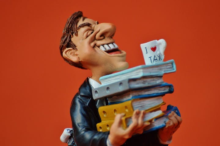 figurine of a person holding tax documents